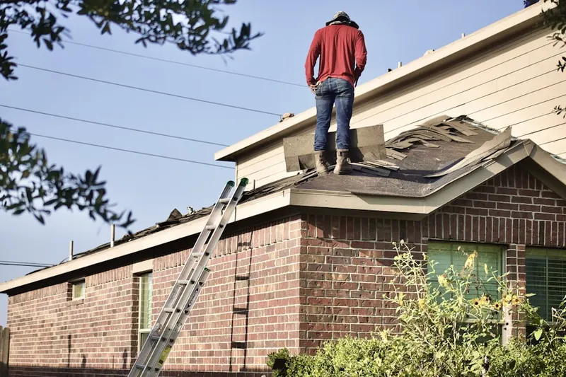 Professional roofer working on a residential roof in Carney